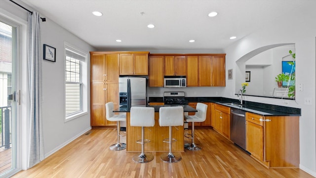 11333 Stratton Ave, Eden Prairie, MN 55344 - kitchen with appliances with stainless steel finishes, light wood finished floors, dark countertops, a kitchen breakfast bar, and recessed lighting