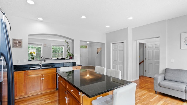 11333 Stratton Ave, Eden Prairie, MN 55344 - kitchen with light wood-style flooring, a kitchen island, recessed lighting, arched walkways, and brown cabinets
