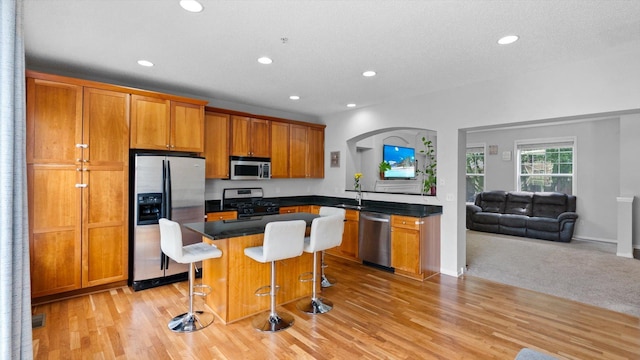 11333 Stratton Ave, Eden Prairie, MN 55344 - kitchen featuring appliances with stainless steel finishes, open floor plan, recessed lighting, brown cabinets, and a breakfast bar area