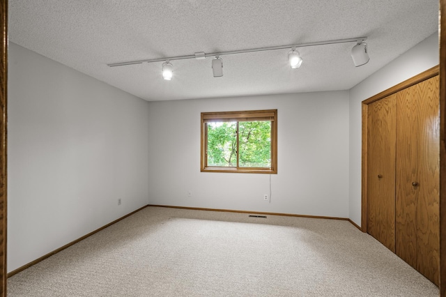 1306 Wynridge Dr, Arden Hills, MN 55112 - unfurnished bedroom with track lighting, carpet, a ceiling fan, a closet, and a textured ceiling