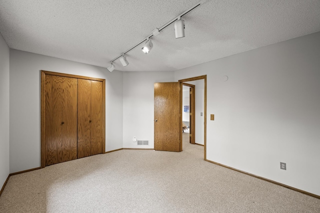 1306 Wynridge Dr, Arden Hills, MN 55112 - unfurnished bedroom featuring a textured ceiling, a closet, carpet, and rail lighting