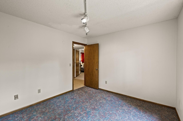 1306 Wynridge Dr, Arden Hills, MN 55112 - empty room with carpet flooring, a textured ceiling, and rail lighting
