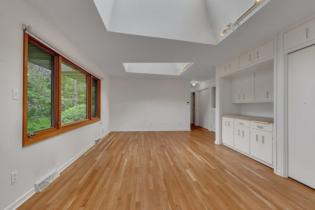 5848 16th Ave SE, Haven Twp, MN 56304 - unfurnished living room featuring a skylight, light wood-style flooring, and track lighting