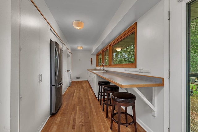5848 16th Ave SE, Haven Twp, MN 56304 - kitchen with freestanding refrigerator, plenty of natural light, light wood-style flooring, and a kitchen breakfast bar