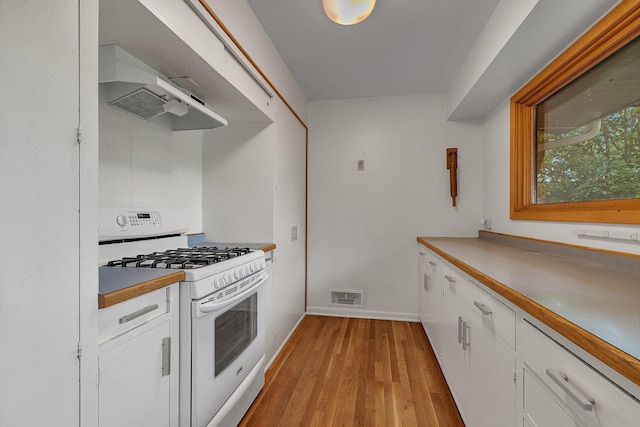5848 16th Ave SE, Haven Twp, MN 56304 - kitchen featuring white gas range oven, extractor fan, light wood-style floors, and white cabinetry