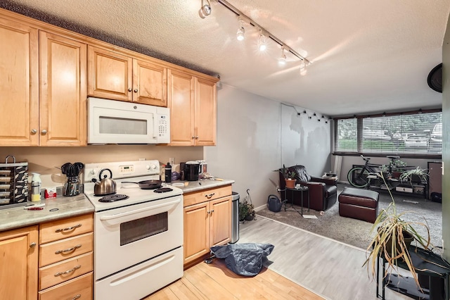 4010 15th Ave S Unit 6D, Minneapolis, MN 55407 - kitchen featuring white appliances, light wood-style floors, light countertops, rail lighting, and a textured ceiling