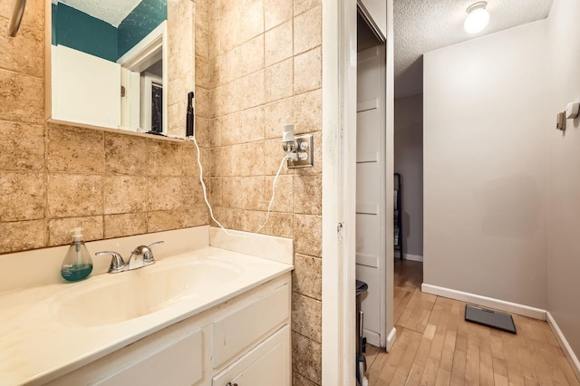4010 15th Ave S Unit 6D, Minneapolis, MN 55407 - bathroom with a textured ceiling, wood finished floors, and vanity