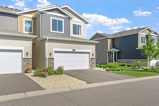 14811 Willemite St NW, Ramsey, MN 55303 - view of front of house featuring stone siding, a garage, and driveway