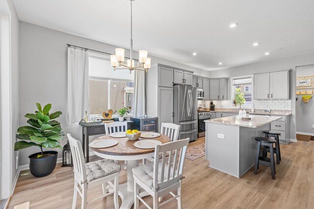 14811 Willemite St NW, Ramsey, MN 55303 - kitchen featuring appliances with stainless steel finishes, a center island, gray cabinetry, tasteful backsplash, and recessed lighting