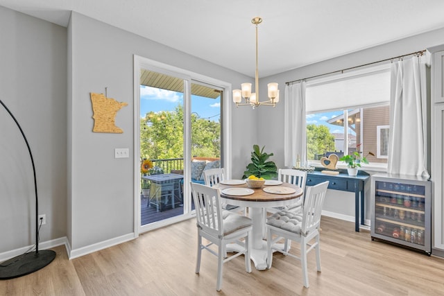 14811 Willemite St NW, Ramsey, MN 55303 - dining room with wine cooler, light wood-style flooring, and a chandelier