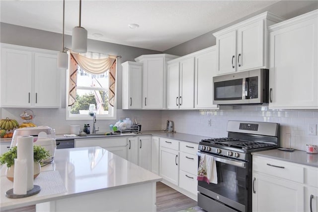 14385 Annapolis Ln N, Dayton, MN 55327 - kitchen featuring appliances with stainless steel finishes, light countertops, white cabinetry, and decorative backsplash