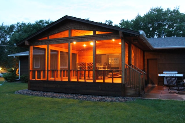 16660 Garland Way W, Lakeville, MN 55068 - rear view of house with a sunroom, a lawn, and a patio area