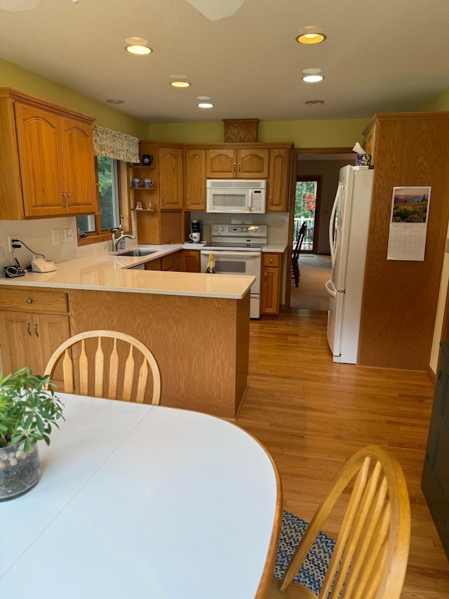 527 Woodside Ct, Shakopee, MN 55379 - kitchen featuring white appliances, a peninsula, light wood-style flooring, light countertops, and recessed lighting