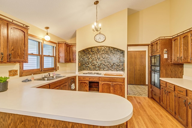 5577 Alameda St, Shoreview, MN 55126 - kitchen with light wood-type flooring, light countertops, a peninsula, brown cabinetry, and black appliances