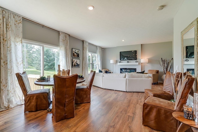 12577 Marshview Dr, Rogers, MN 55374 - dining area featuring hardwood / wood-style flooring, a glass covered fireplace, and recessed lighting
