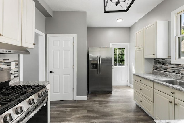 2815 Girard Ave N, Minneapolis, MN 55411 - kitchen featuring stainless steel appliances, backsplash, healthy amount of natural light, and under cabinet range hood