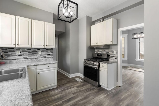 2815 Girard Ave N, Minneapolis, MN 55411 - kitchen featuring stainless steel gas range oven, a chandelier, under cabinet range hood, decorative backsplash, and white cabinets
