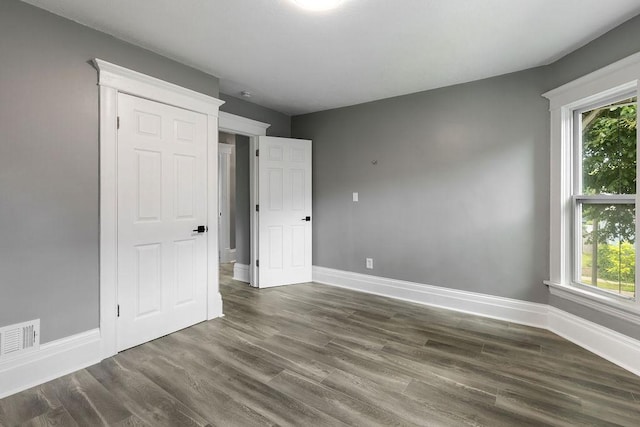 2815 Girard Ave N, Minneapolis, MN 55411 - unfurnished bedroom with wood finished floors and multiple windows