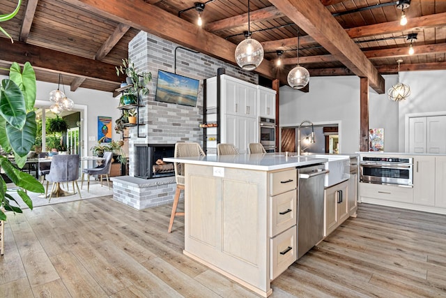 1466 Highview Ave, Eagan, MN 55121 - kitchen featuring a wood ceiling with exposed beams, stainless steel appliances, light wood-type flooring, light countertops, and a kitchen island with sink