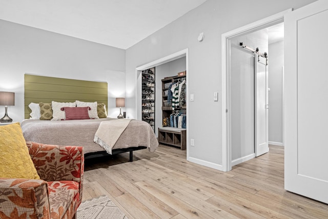 1466 Highview Ave, Eagan, MN 55121 - bedroom with light wood-style floors, a barn door, a spacious closet, and a closet