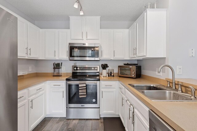 6845 Christian Curv, Woodbury, MN 55125 - kitchen with stainless steel appliances, dark wood-style floors, light countertops, white cabinets, and a textured ceiling