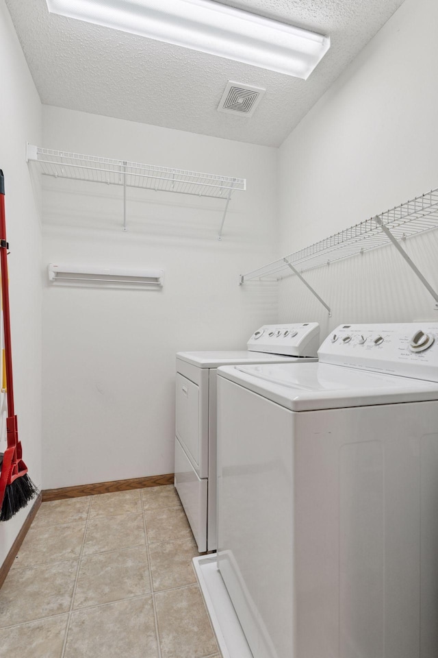 6845 Christian Curv, Woodbury, MN 55125 - laundry area featuring separate washer and dryer, a textured ceiling, and light tile patterned floors