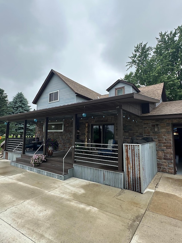 28040 Csah 25, Swede Grove Twp, MN 56243 - view of front of house with stone siding, covered porch, and roof with shingles
