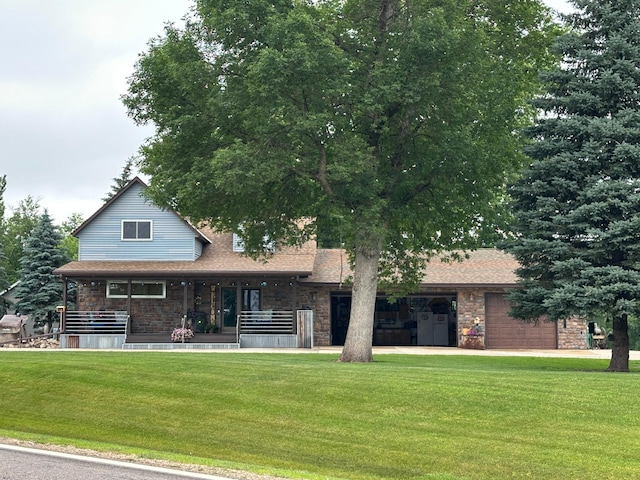 28040 Csah 25, Swede Grove Twp, MN 56243 - view of front of home with stone siding, a garage, a front lawn, a porch, and a shingled roof