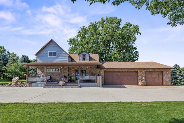28040 Csah 25, Swede Grove Twp, MN 56243 - view of front of property featuring a garage, concrete driveway, stone siding, covered porch, and a front lawn
