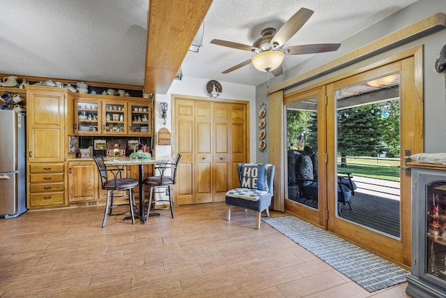 28040 Csah 25, Swede Grove Twp, MN 56243 - bar area featuring freestanding refrigerator, a textured ceiling, ceiling fan, and light wood-type flooring