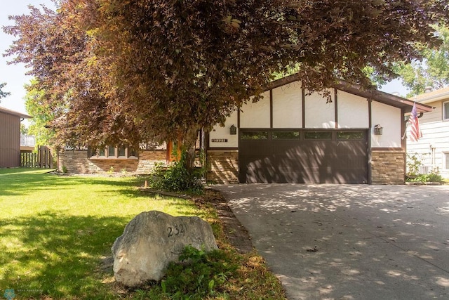 2321 17th Ave S, Fargo, ND 58103 - view of front of house with stone siding, concrete driveway, a front lawn, and a garage