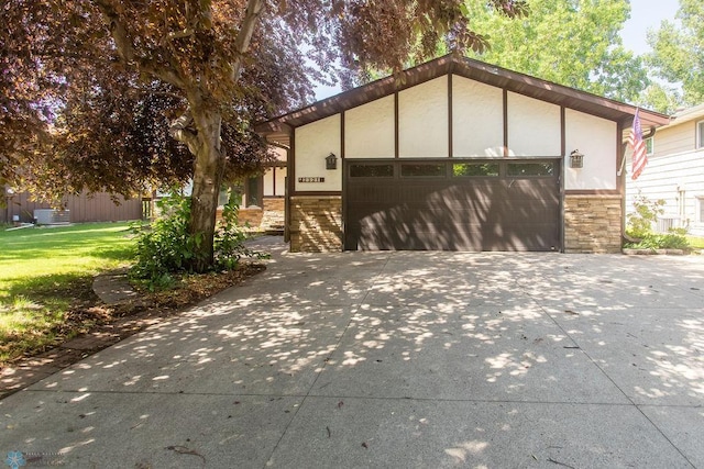 2321 17th Ave S, Fargo, ND 58103 - view of front of property with stone siding, a garage, and a front lawn