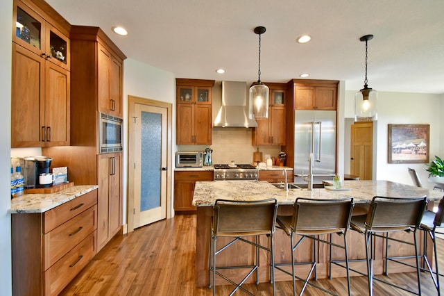 26888 734th Ave, Dassel Twp, MN 55325 - kitchen with wall chimney exhaust hood, built in appliances, brown cabinetry, light wood finished floors, and recessed lighting