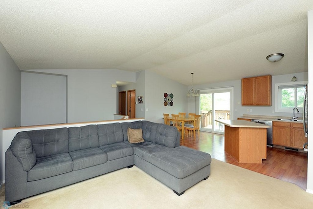 2441 60th Ave S, Fargo, ND 58104 - living area featuring dark wood-style flooring, vaulted ceiling, plenty of natural light, a textured ceiling, and a chandelier