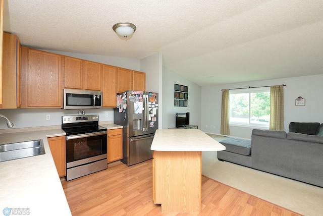 2441 60th Ave S, Fargo, ND 58104 - kitchen with appliances with stainless steel finishes, open floor plan, lofted ceiling, light wood-style flooring, and light countertops