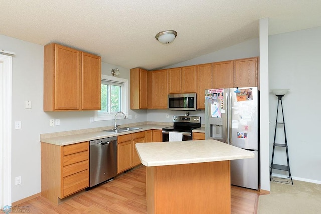2441 60th Ave S, Fargo, ND 58104 - kitchen featuring stainless steel appliances, lofted ceiling, light countertops, a center island, and light wood-style flooring