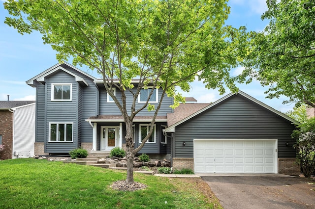8798 Fountain Ln N, Maple Grove, MN 55311 - view of front of house with brick siding, driveway, a front lawn, a garage, and a shingled roof