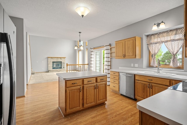8798 Fountain Ln N, Maple Grove, MN 55311 - kitchen with stainless steel dishwasher, light wood-style floors, a kitchen island, a textured ceiling, and a fireplace