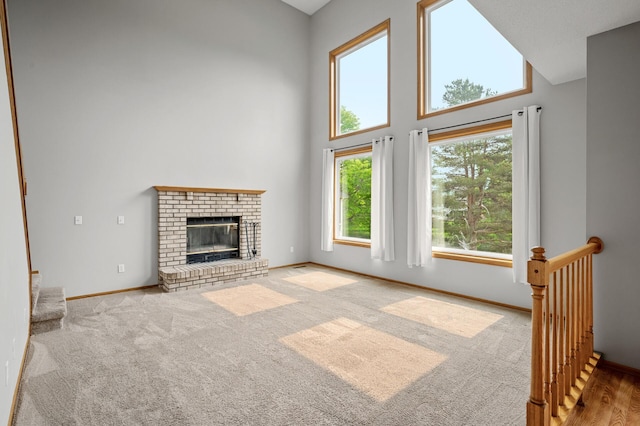 8798 Fountain Ln N, Maple Grove, MN 55311 - unfurnished living room with a high ceiling, carpet floors, and a fireplace