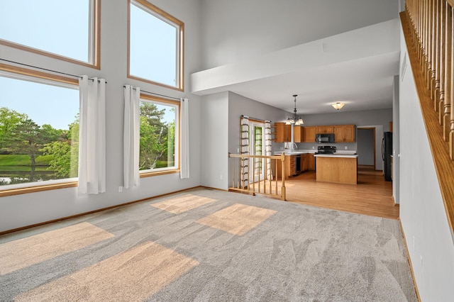 8798 Fountain Ln N, Maple Grove, MN 55311 - unfurnished living room with light colored carpet, a chandelier, and a high ceiling