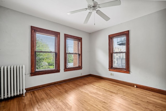 1812 Clinton Ave Unit 203, Minneapolis, MN 55404 - unfurnished room featuring radiator heating unit, healthy amount of natural light, light wood-type flooring, and a ceiling fan