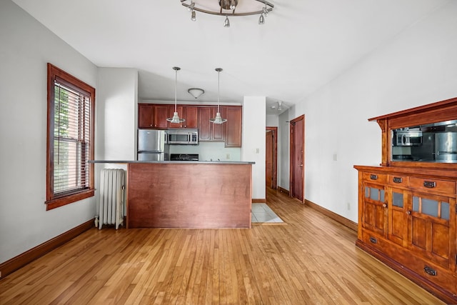 1812 Clinton Ave Unit 203, Minneapolis, MN 55404 - kitchen featuring radiator, appliances with stainless steel finishes, light wood-type flooring, and hanging light fixtures