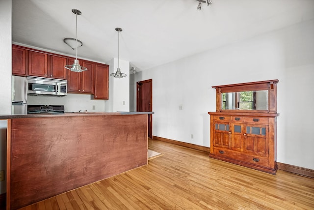 1812 Clinton Ave Unit 203, Minneapolis, MN 55404 - kitchen featuring stainless steel appliances, light wood-style floors, pendant lighting, and dark countertops