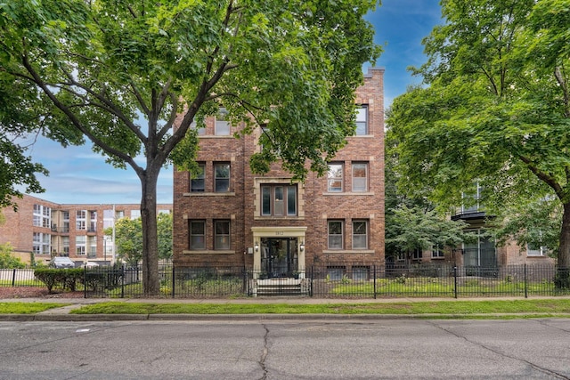 1812 Clinton Ave Unit 203, Minneapolis, MN 55404 - view of front of property featuring brick siding, a fenced front yard, and a chimney