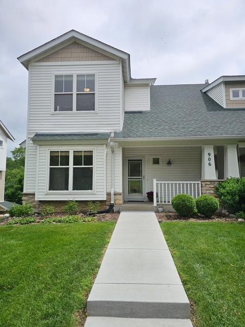906 New Century Blvd S, Maplewood, MN 55119 - view of front of property with stone siding, a shingled roof, a front yard, and covered porch
