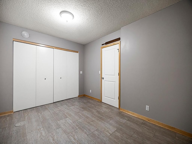 906 New Century Blvd S, Maplewood, MN 55119 - unfurnished bedroom featuring a textured ceiling, a closet, and wood tiled floors