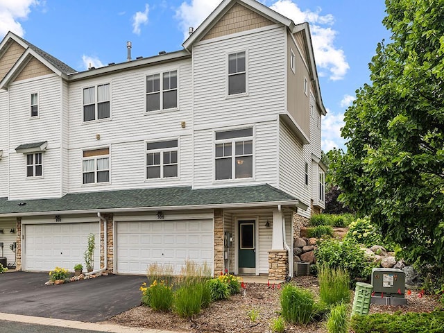 906 New Century Blvd S, Maplewood, MN 55119 - townhome / multi-family property with stone siding, a garage, driveway, and a shingled roof