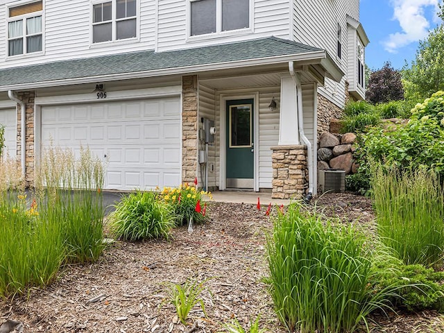 906 New Century Blvd S, Maplewood, MN 55119 - property entrance featuring stone siding, roof with shingles, and an attached garage