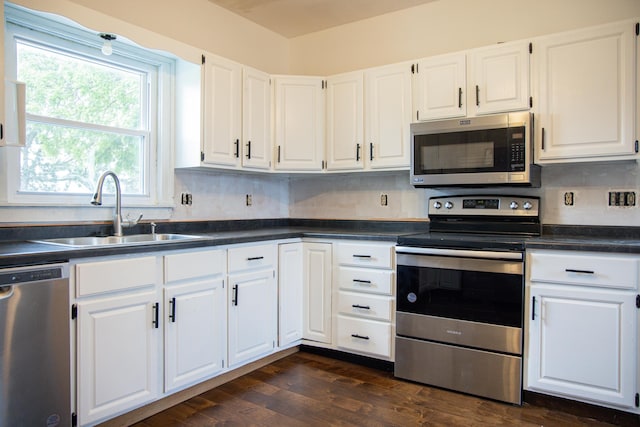 305 2nd Ave SE, Plainview, MN 55964 - kitchen featuring appliances with stainless steel finishes, white cabinets, dark wood-style floors, dark countertops, and backsplash
