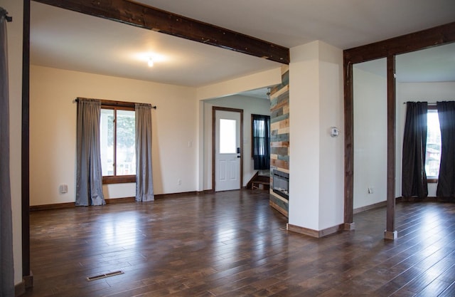 305 2nd Ave SE, Plainview, MN 55964 - empty room with healthy amount of natural light, beam ceiling, and dark wood finished floors